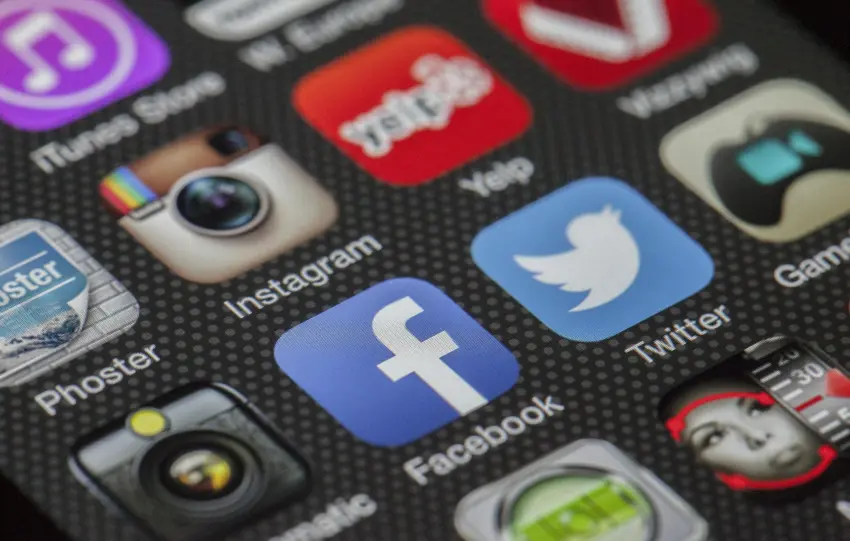 Close-up image of various social media app icons on a smartphone screen.
